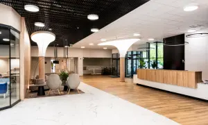 Nowoczesne wnętrze recepcji sanatorium Argentyt Dąbki z wygodnymi fotelami i drewnianą ladą.
