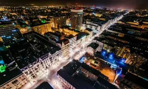 Nocny widok na najdłuższy deptak w Polsce, rozświetlony iluminacjami i światłami miasta.