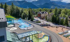 Basen z widokiem na Tatry. Idealne tatry atrakcje dla leniwych: relaks w wodzie, zjeżdżalnie i leżaki.