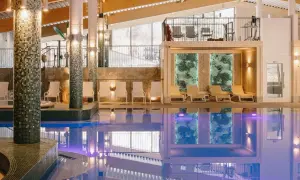 Basen w hotelu z leżakami i widokiem na góry.