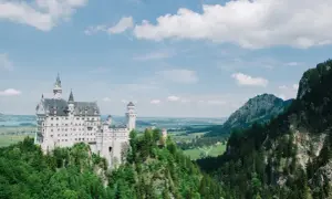 Bajkowy zamek Neuschwanstein, jeden z najpiękniejszych zamków w Europie, wznosi się na skalistym wzgórzu otoczonym zielonymi lasami.