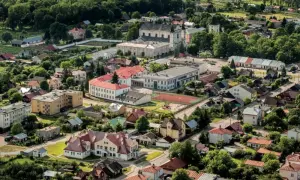 Widok z lotu ptaka na Janów Podlaski. Widać zabudowania, kościół i tereny zielone. Atrakcje tego miejsca zachęcają do odwiedzin.