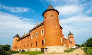 Zamek w Tykocinie, jedna z atrakcji Białegostoku i okolic. Ceglana budowla z wieżami pod błękitnym niebem.