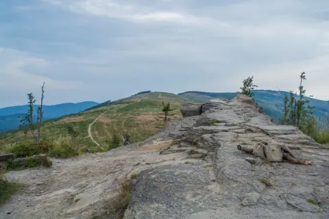 Kamienista ścieżka prowadzi przez zielone zbocza, ukazując malownicze beskid śląski szczyty.