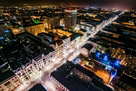 Nocny widok na najdłuższy deptak w Polsce, rozświetlony iluminacjami i światłami miasta.