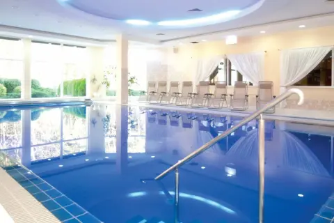 Relaks w hotelach nad morzem z basenem. Czysta, błękitna woda basenu, leżaki i widok na zieleń.