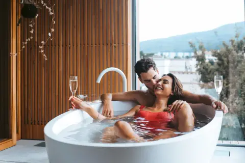 Para relaksu we dwoje w hotelu bez dzieci. Para w wannie z szampanem, z widokiem na góry.