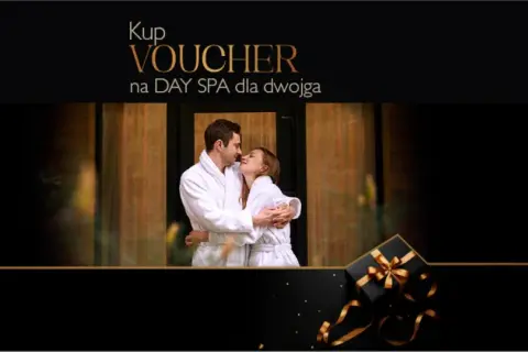 Para dwojga w szlafrokach przytulająca się na tle drewnianych drzwi. Obok czarny prezent ze złotą wstążką. Idealny voucher na weekend w spa dla dwojga.