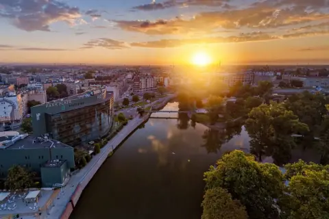 Zachód słońca nad Wrocławiem, widok na hotel HP Plaza i rzekę.