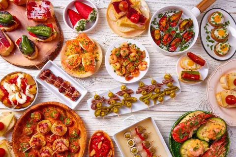 Bogactwo hiszpańskiego jedzenia: tapas z krewetkami, małżami, owocami morza, wędlinami i warzywami.