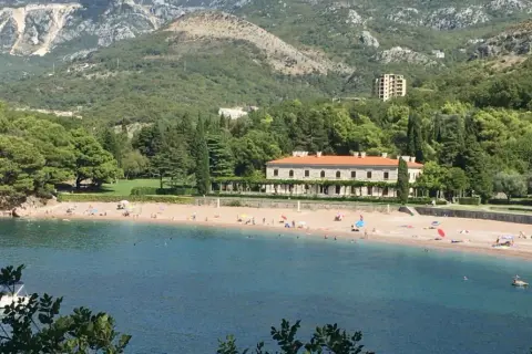 Piękne czarnogóra plaże z turkusową wodą, piaszczystym brzegiem i luksusową willą w tle.