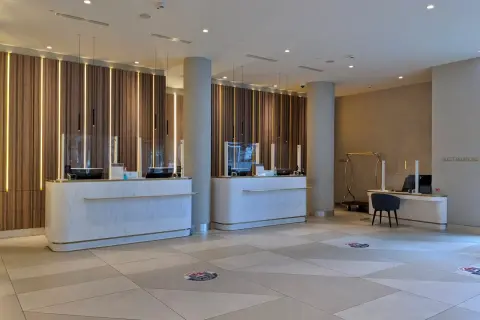 Eleganckie recepcje w Radisson Collection Hotel Warsaw, z nowoczesnym oświetleniem i marmurowymi blatami, zapraszają do komfortowego zameldowania.