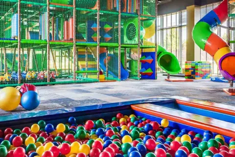 Kolorowa sala zabaw z basenem pełnym piłek i zjeżdżalniami. Idealne miejsce dla dzieci w rodzinnym hotelu nad morzem.