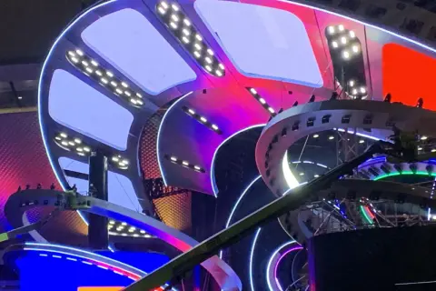 Kolorowa, futurystyczna scena z oświetleniem LED, przygotowywana na Sylwester w Katowicach.