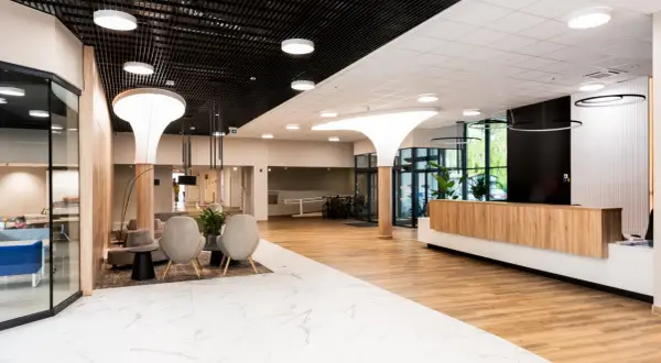 Nowoczesne wnętrze recepcji sanatorium Argentyt Dąbki z wygodnymi fotelami i drewnianą ladą.