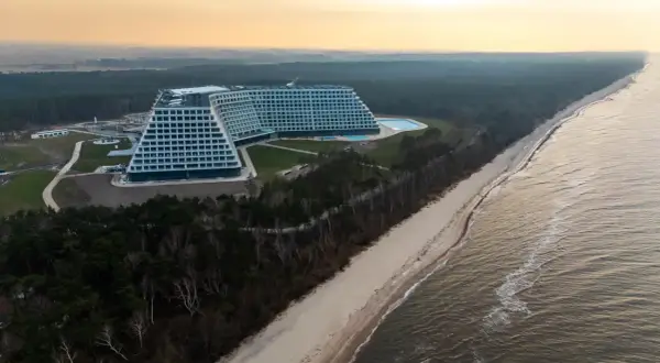 Nowo otwarty hotel nad morzem, z basenem i widokiem na plażę i las. Architektura przypomina schody.