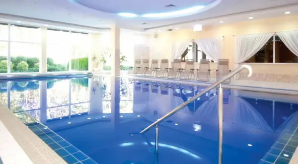 Relaks w hotelach nad morzem z basenem. Czysta, błękitna woda basenu, leżaki i widok na zieleń.