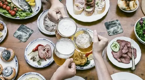 Uczta z daniami kuchni czeskiej: ryba, kiełbasa, pieczywo, piwo i słodkie wypieki.