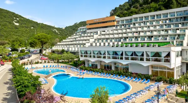 Hotel Narcis Chorwacja z basenami i leżakami, otoczony zielenią i górami.