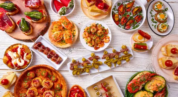Bogactwo hiszpańskiego jedzenia: tapas z krewetkami, małżami, owocami morza, wędlinami i warzywami.
