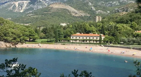 Piękne czarnogóra plaże z turkusową wodą, piaszczystym brzegiem i luksusową willą w tle.