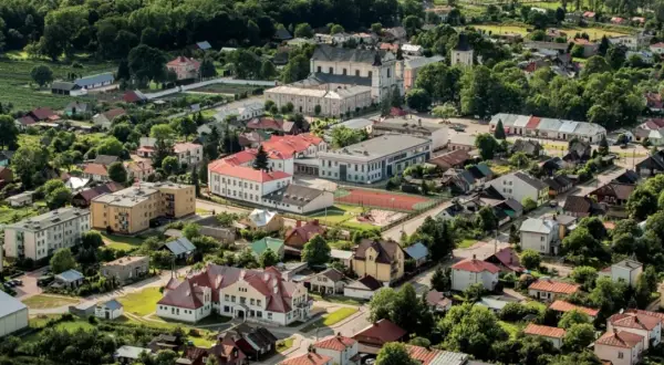 Widok z lotu ptaka na Janów Podlaski. Widać zabudowania, kościół i tereny zielone. Atrakcje tego miejsca zachęcają do odwiedzin.