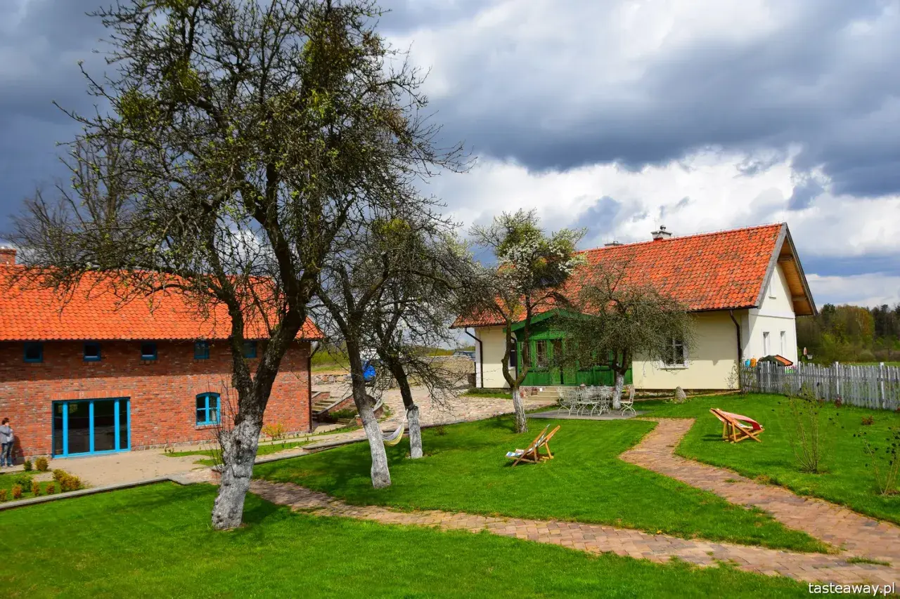 Malownicze zabudowania z cegły i tynku, z pomarańczowymi dachami, otoczone zielonym ogrodem. Idealne na weekend we dwoje w Polsce.