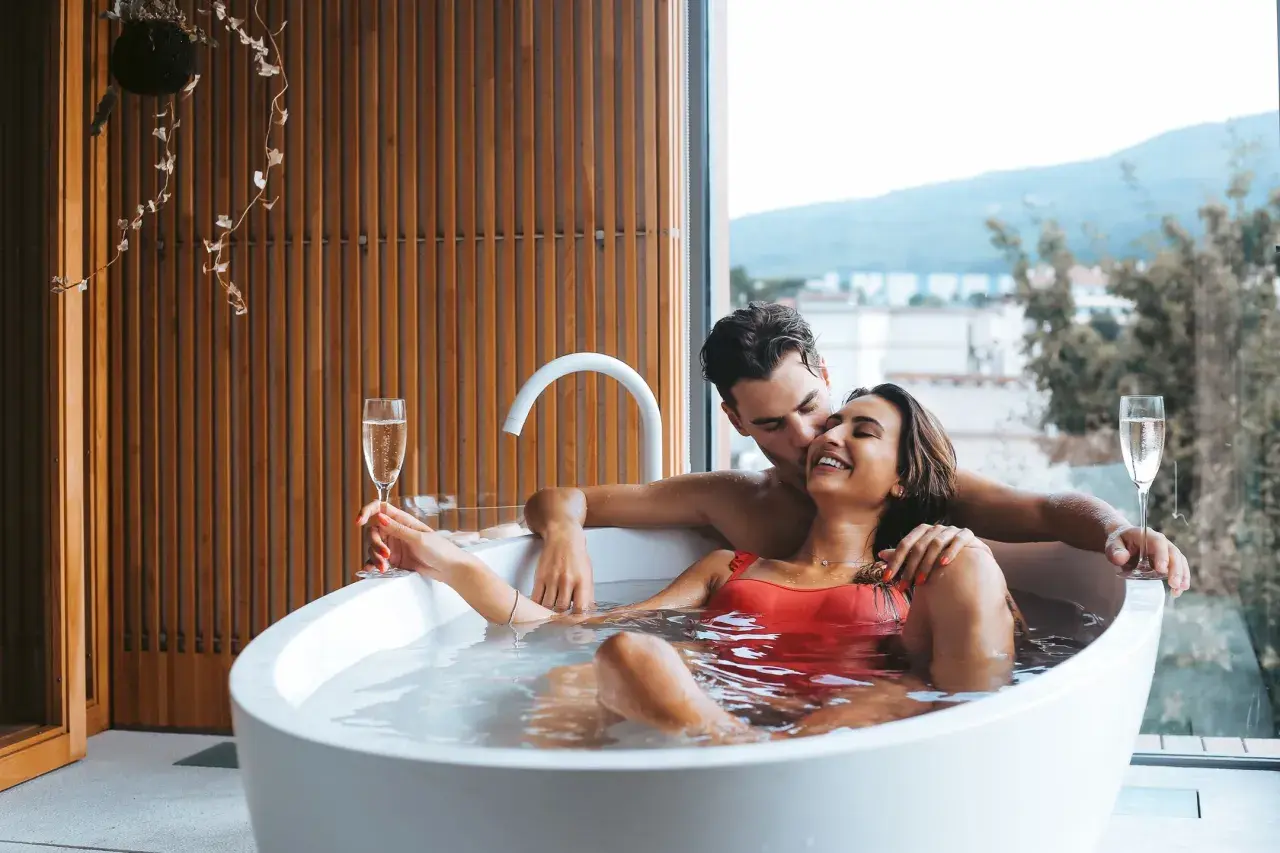 Para relaksu we dwoje w hotelu bez dzieci. Para w wannie z szampanem, z widokiem na góry.