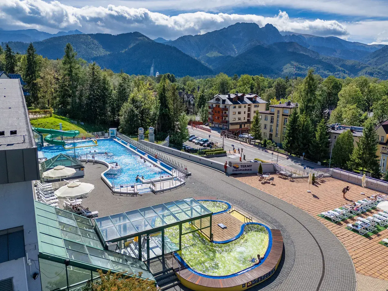 Basen z widokiem na Tatry. Idealne tatry atrakcje dla leniwych: relaks w wodzie, zjeżdżalnie i leżaki.