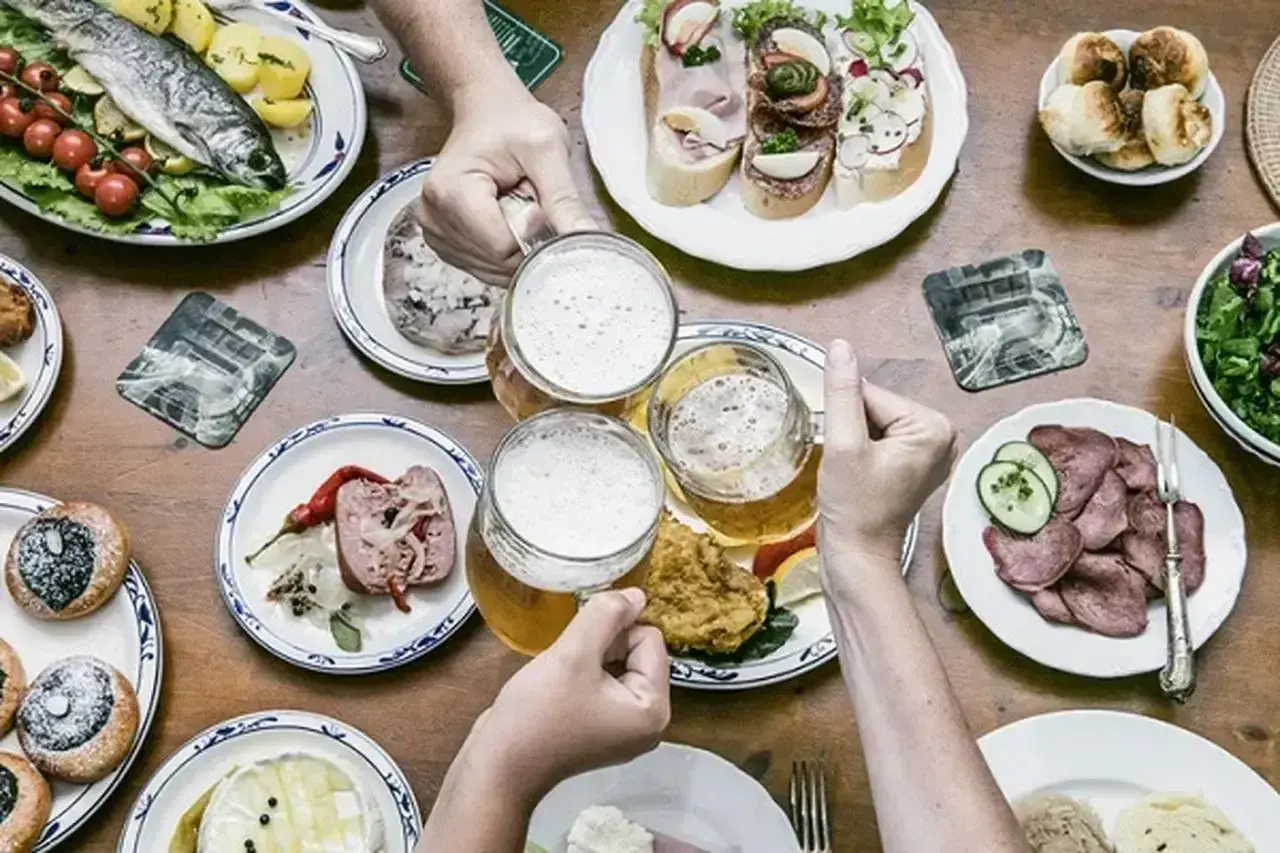Uczta z daniami kuchni czeskiej: ryba, kiełbasa, pieczywo, piwo i słodkie wypieki.