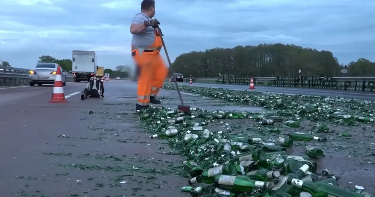 Drogi z butelkami piwa, z czym kojarzą się Niemcy. Pracownik w pomarańczowym kombinezonie sprząta autostradę.