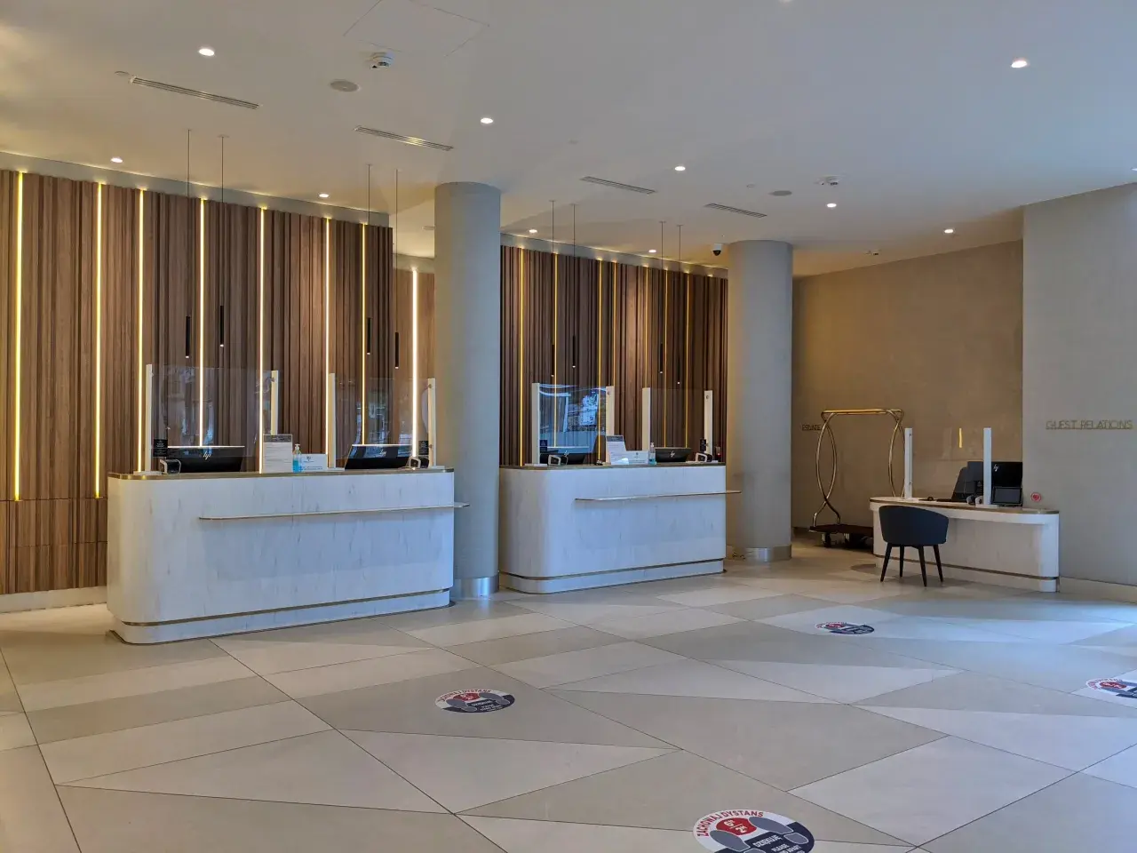 Eleganckie recepcje w Radisson Collection Hotel Warsaw, z nowoczesnym oświetleniem i marmurowymi blatami, zapraszają do komfortowego zameldowania.