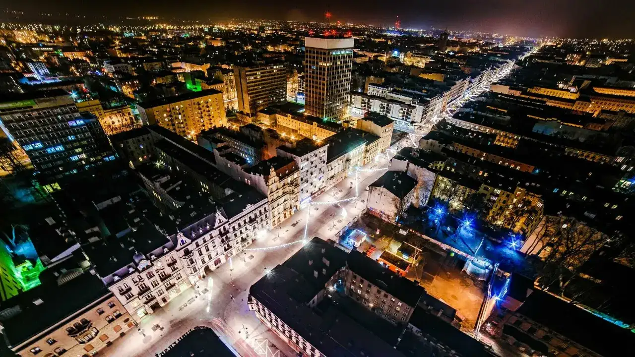 Nocny widok na najdłuższy deptak w Polsce, rozświetlony iluminacjami i światłami miasta.
