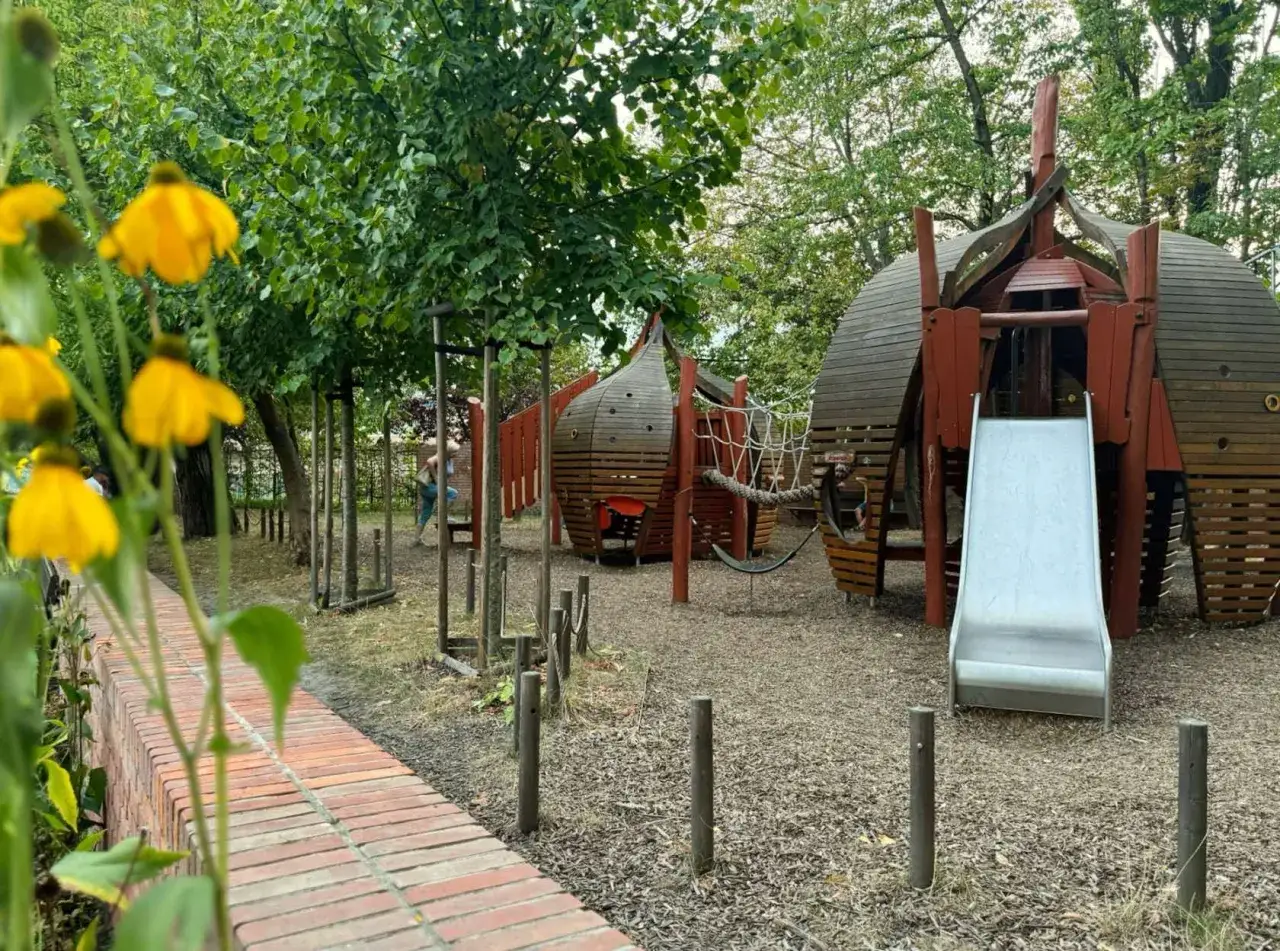 Kraków z dzieckiem: plac zabaw z drewnianymi konstrukcjami i zjeżdżalnią.