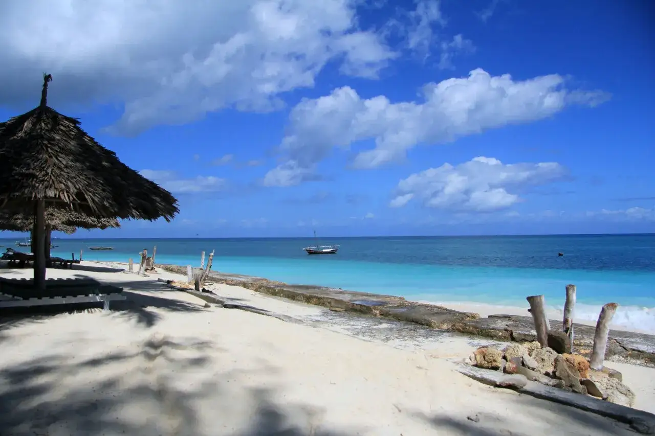 Rajska plaża na Zanzibarze, z łódką na turkusowym morzu. Idealne miejsce, by odpocząć i zobaczyć cuda natury.