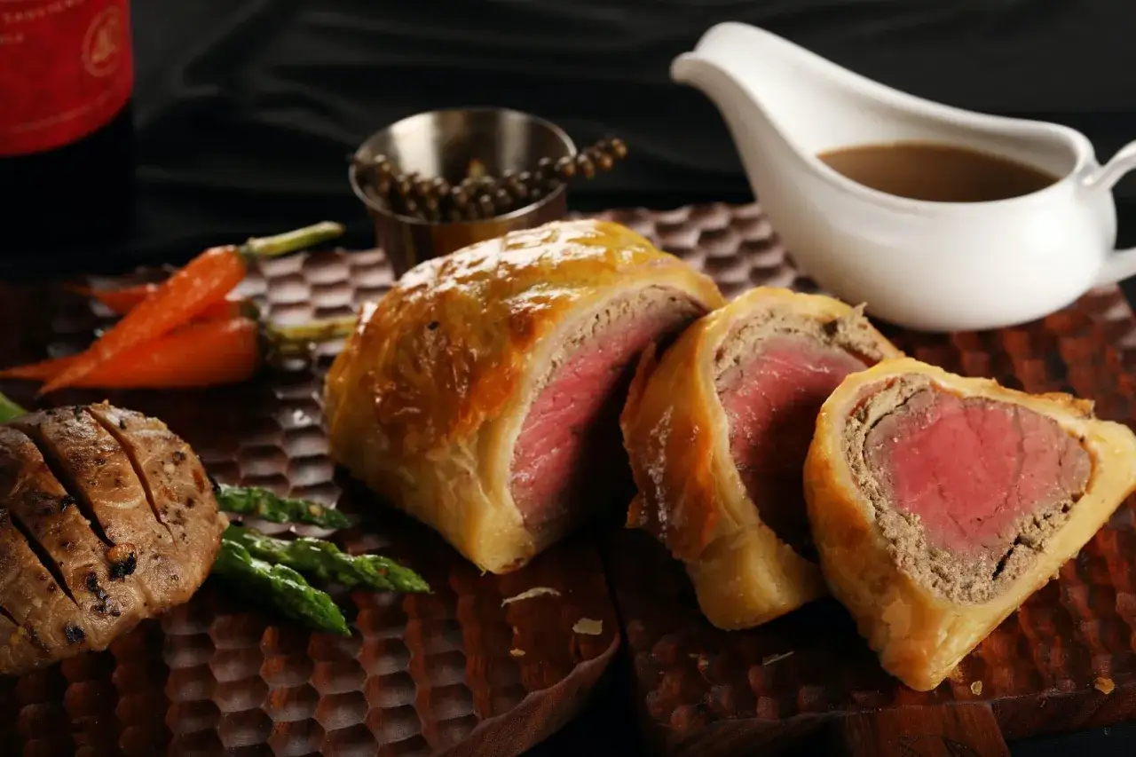Wykwintne jedzenie w Wielkiej Brytanii: Beef Wellington z pieczonymi warzywami i sosem.