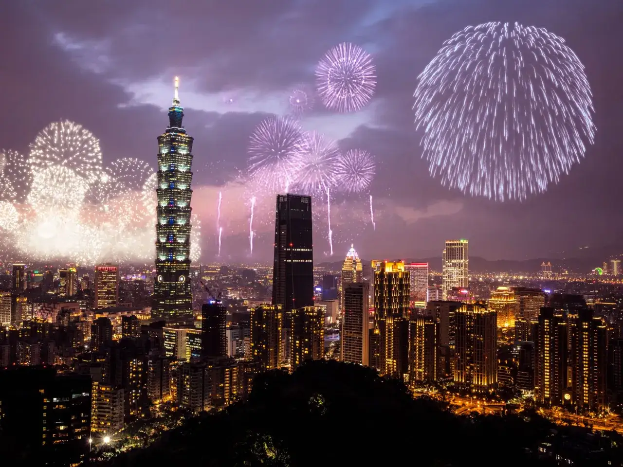 Spektakularny sylwester za granicą! Fajerwerki rozświetlają nocne niebo nad Tajpej, z wieżą Taipei 101 w centrum.