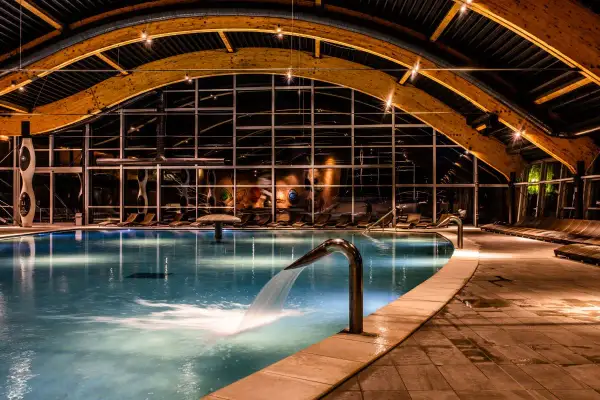 Relaks w basenie hotel terme sveti martin. Woda kaskadą spływa z metalowej rynny, tworząc fale.