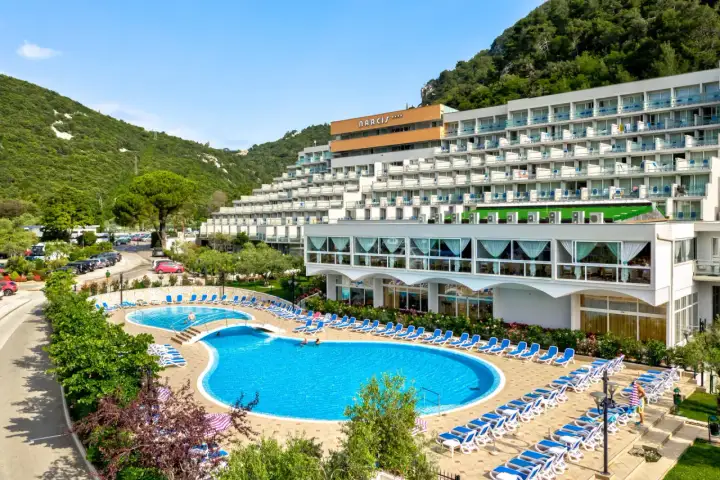 Hotel Narcis Chorwacja z basenami i leżakami, otoczony zielenią i górami.